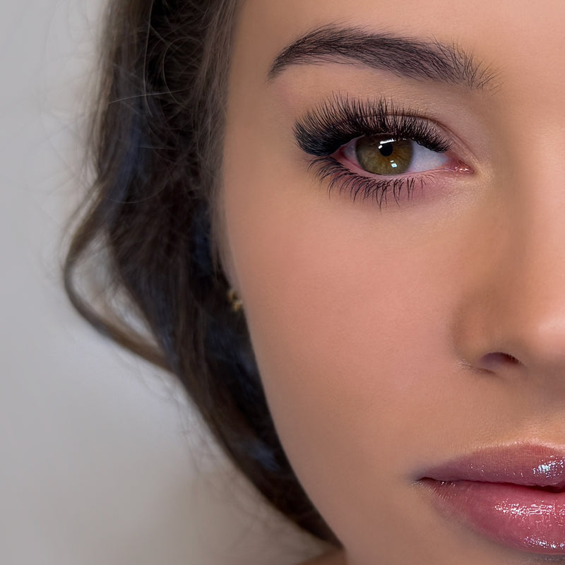 Half face of a model showing example of bottom eye lash extensions on her eye