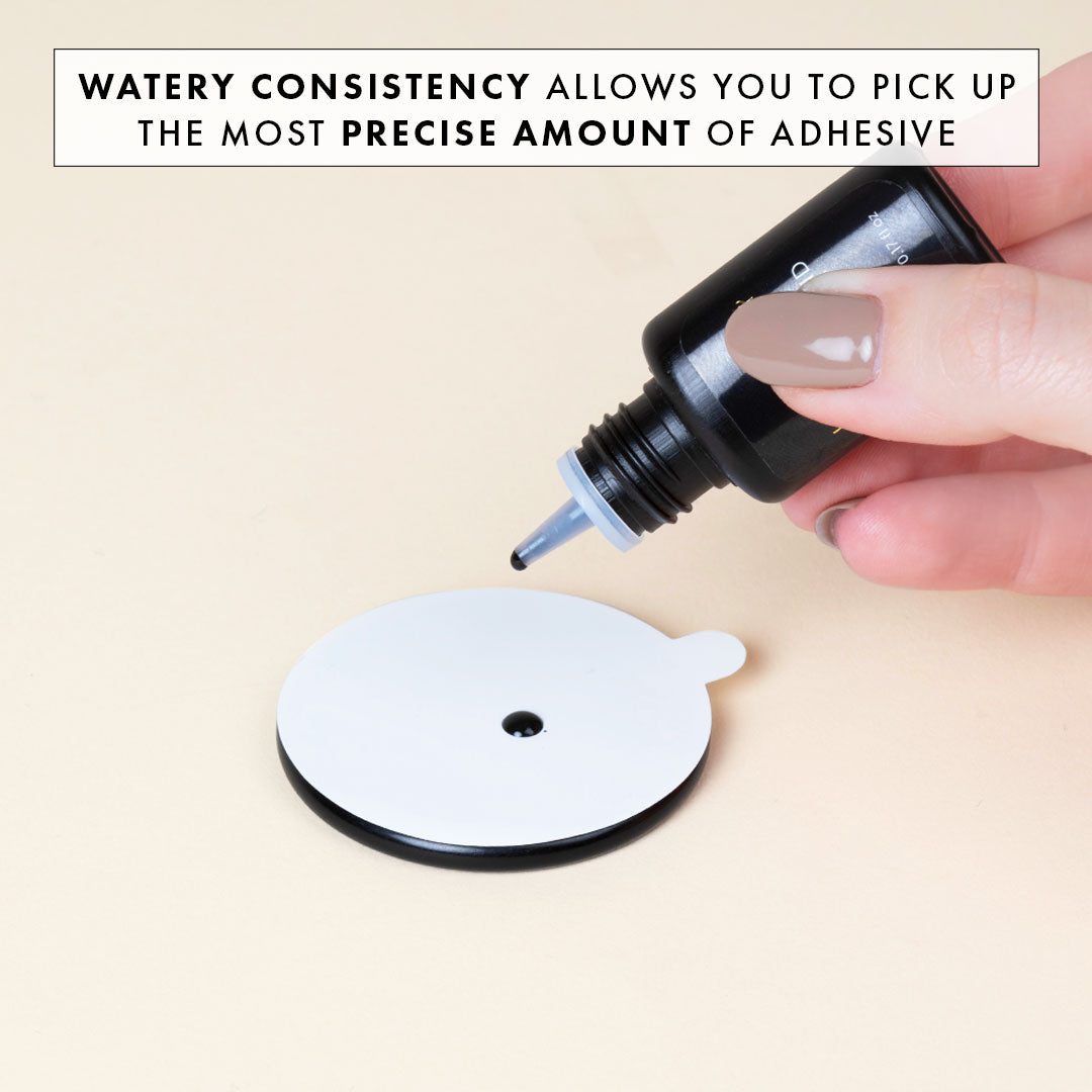 a drop of royal bond eyelash extension glue being dispensed onto a jade stone